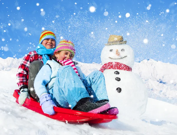 Hermanos jugando trineo de nieve — Foto de Stock