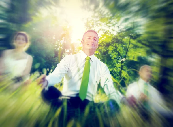Business people meditating in woods — Stock Photo, Image