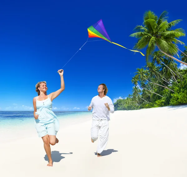 Casal voando pipa na praia — Fotografia de Stock