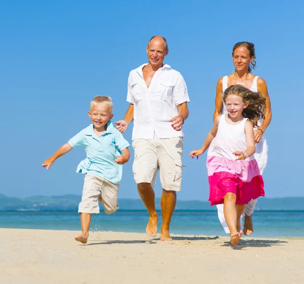 Familia corriendo en la playa Imagen De Stock