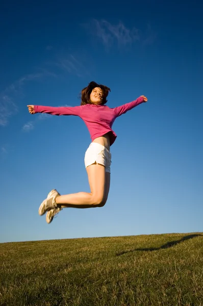 Женщина прыгает с поднятыми руками — стоковое фото