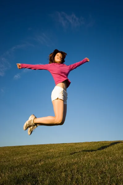 Woman jumping with her arms raised Royalty Free Stock Photos