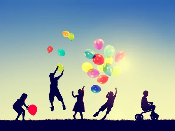 Niños pequeños con globos — Foto de Stock