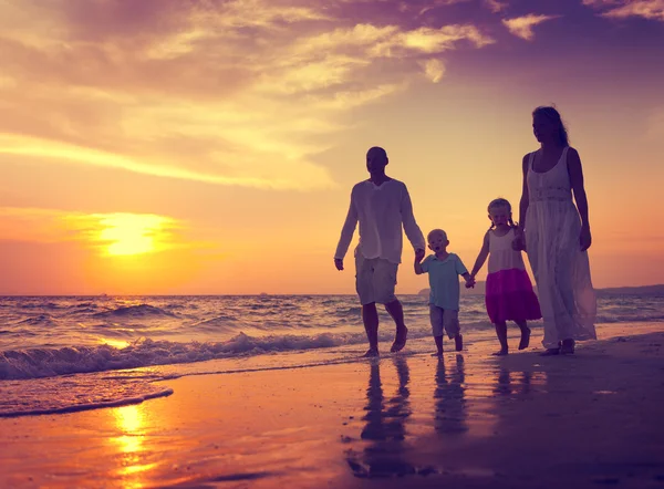 Familie wandelen op het strand bij zonsondergang — Stockfoto