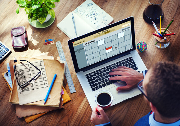 man working on laptop with Calendar