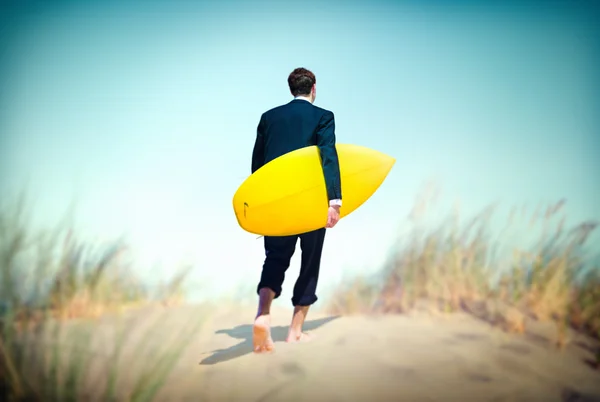 Geschäftsmann mit Surfbrett am Strand — Stockfoto