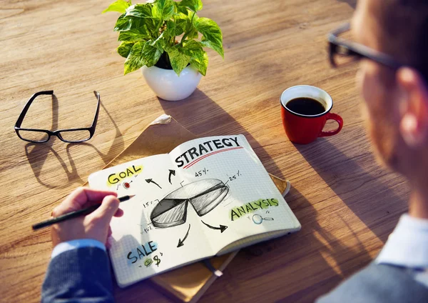 Man draws in a notebook business strategy — Stock Photo, Image