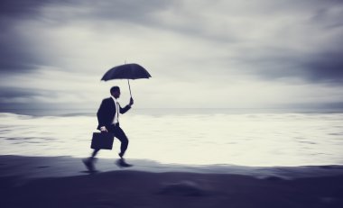 Endişeli işadamı çalıştıran Plajda şemsiye ile
