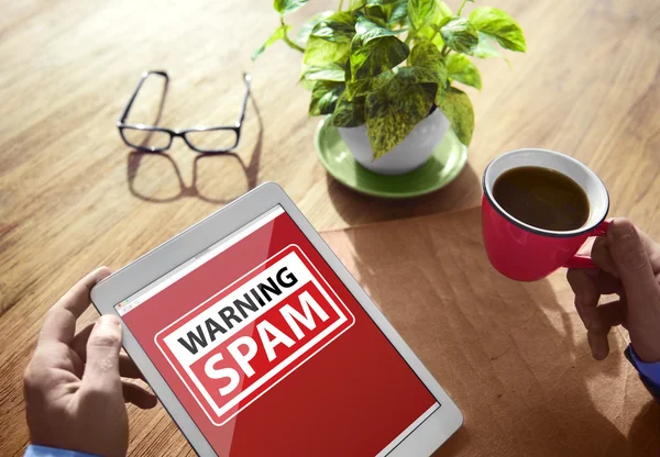 Hombre usando una tableta digital con spam de advertencia — Foto de Stock