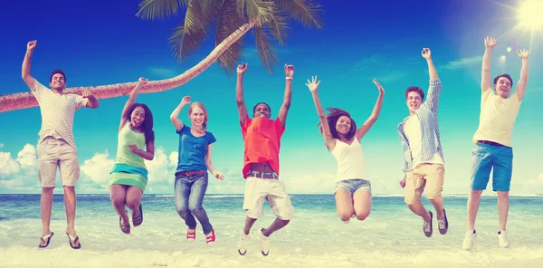 Happy vrienden springen op het strand — Stockfoto