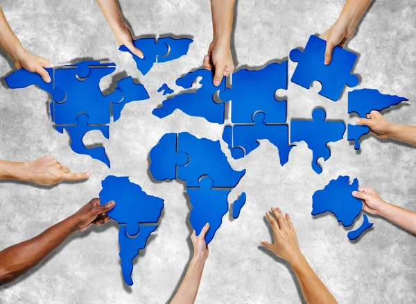People Forming World Map with Puzzle Pieces — Stock Photo, Image