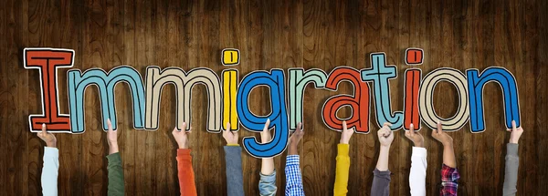 Χέρια που κρατούν την λέξη μετανάστευση — Φωτογραφία Αρχείου