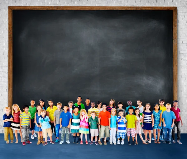 Grupa dzieci wieloetnicznym z tablicy — Zdjęcie stockowe
