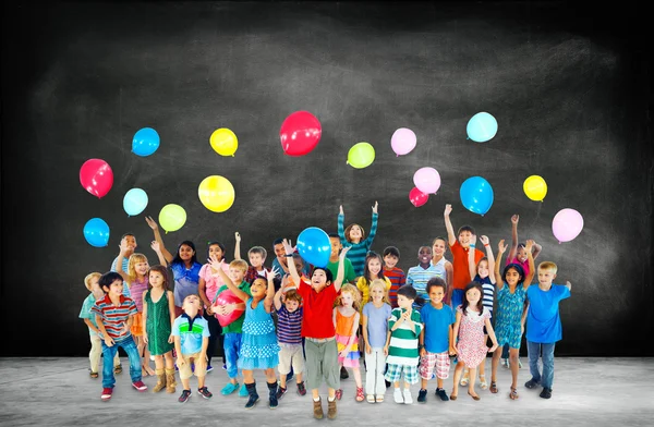 Grupo de niños multiétnicos con globos —  Fotos de Stock