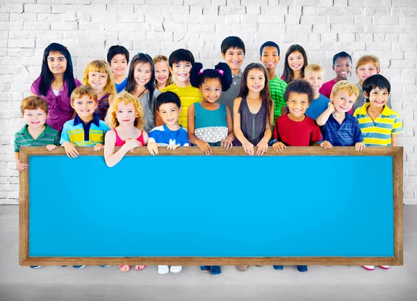 Група багатоетнічних дітей з дошкою — стокове фото