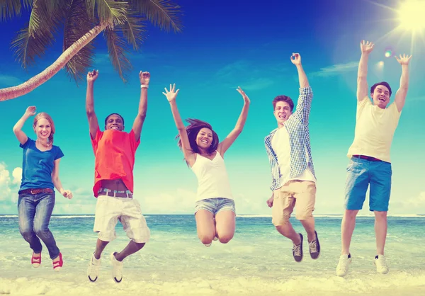 Folk hoppar på stranden, vänskap koncept — Stockfoto