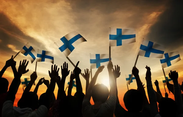 Silhouettes of People Holding the Flags of Finland — Stock Photo, Image