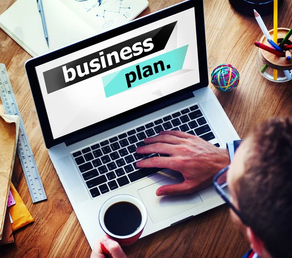 Uomo che lavora su laptop con Business Plan — Foto Stock