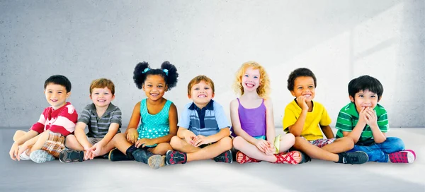 Різноманітність дітей, що сидять разом — стокове фото