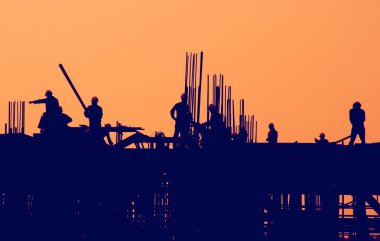 Gün batımında inşaat işçileri