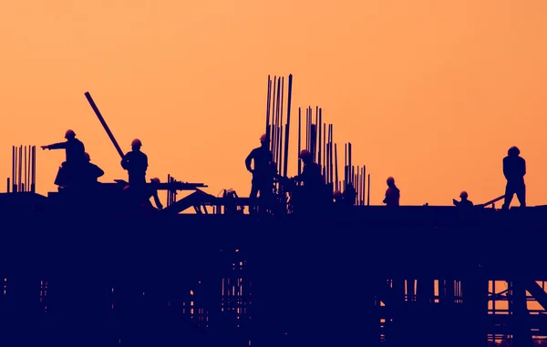 Construction workers at sunset — Stock Photo, Image