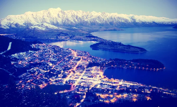 Paesaggio urbano e lago con montagne — Foto Stock