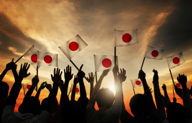 Bir grup insan Japonya bayrakları sallayarak