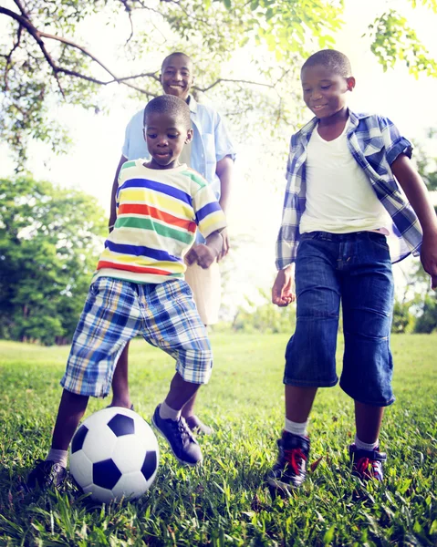 Pai e filhos jogando futebol — Fotografia de Stock