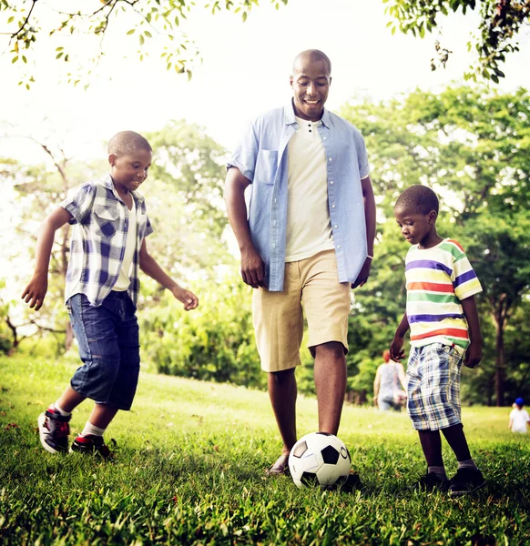 Pai e filhos jogando futebol — Fotografia de Stock