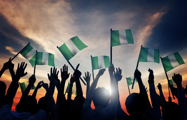 Gruppe von Menschen, die Flaggen Nigerias schwenken — Stockfoto