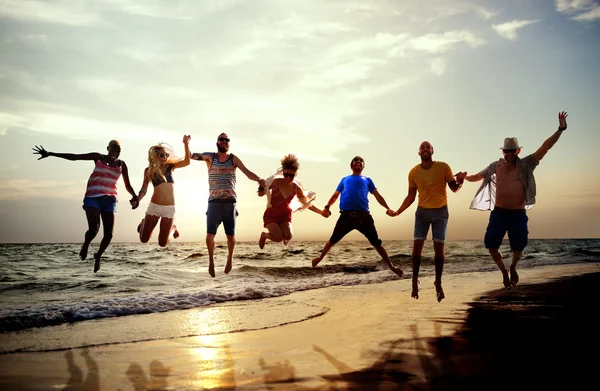 Happy Friends pulando na praia — Fotografia de Stock