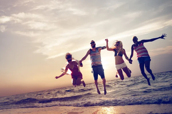 Happy friends jumping on the beach — Stock Photo, Image