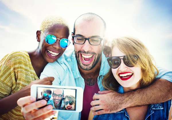 Diversos amigos que se unen usando el concepto de teléfono inteligente —  Fotos de Stock