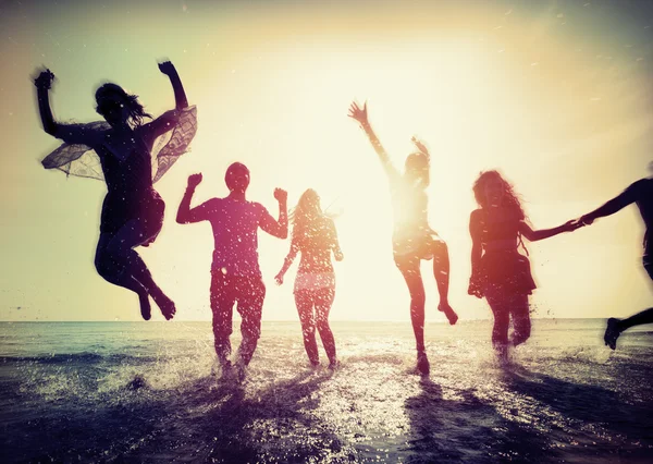 Amici felici che saltano sulla spiaggia — Foto Stock