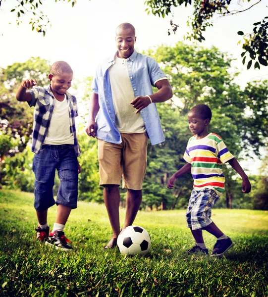 Pai e filhos jogando futebol — Fotografia de Stock