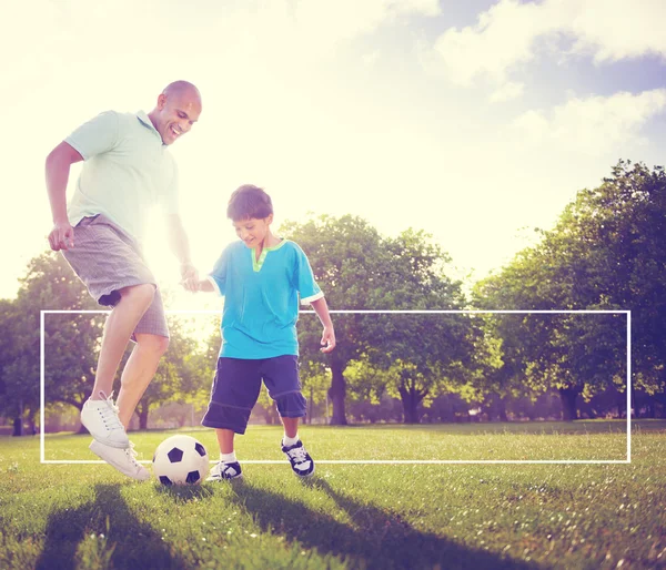 Far och son spelar fotboll — Stockfoto