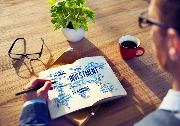 Man skriver i anteckningsboken med investeringsverksamhet — Stockfoto
