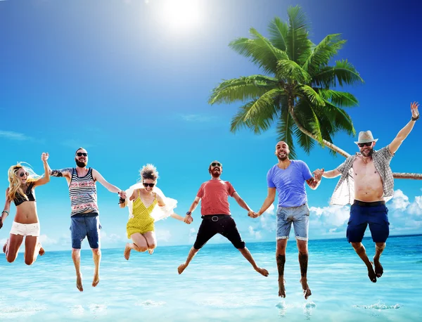 Glückliche Freunde springen am Strand — Stockfoto