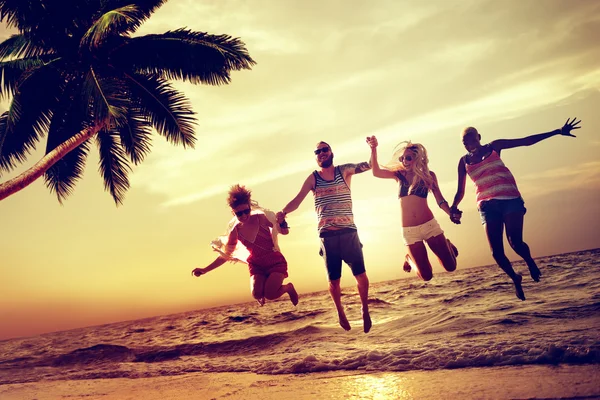 Happy friends jumping on the beach — Stock Photo, Image