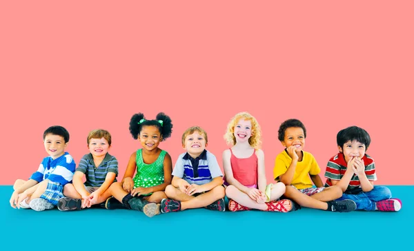 Diversiteit kinderen zitten samen — Stockfoto