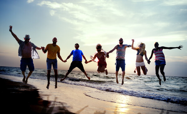 happy friends jumping on the beach