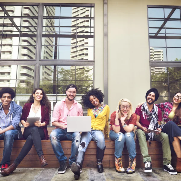 Amigos sentados en el banco con computadoras portátiles — Foto de Stock