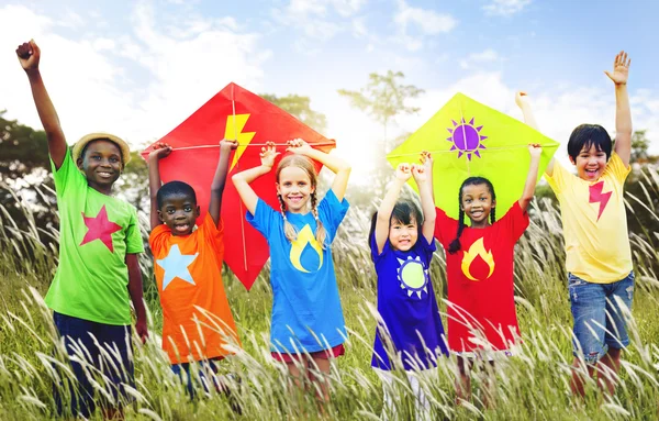 Kinderen spelen vliegers speelse concept — Stockfoto
