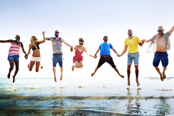 Happy friends jumping on the beach — Stock Photo, Image