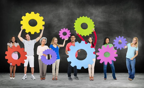 Diversidad Personas sosteniendo engranajes —  Fotos de Stock