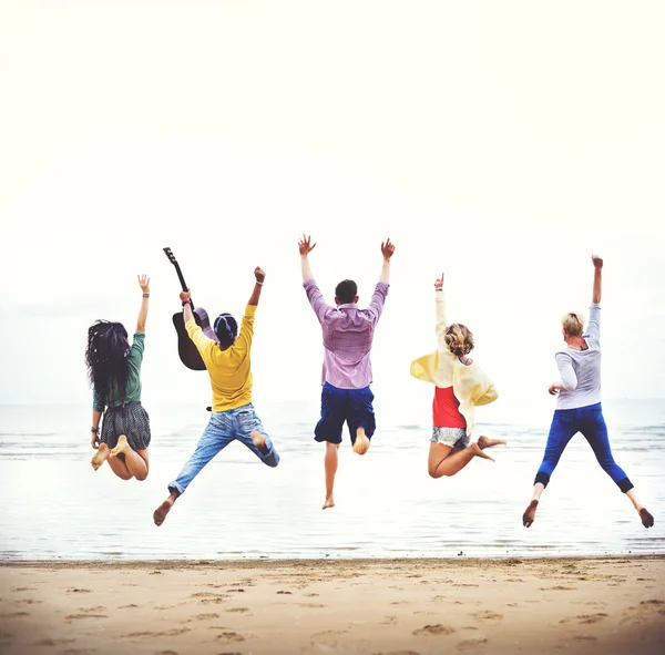 Glückliche Freunde springen am Strand — Stockfoto