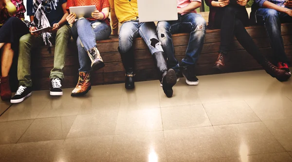 Vänner sitter på bänken med bärbara datorer — Stockfoto