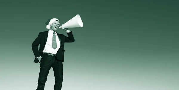 Businessman with Megaphone in santa claus hat — Stockfoto