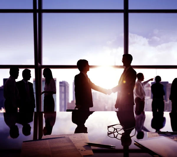 Silhouettes of business people shaking hands — Stock Photo, Image