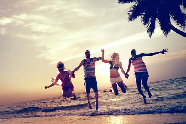 Happy friends jumping on the beach — Stock Photo, Image